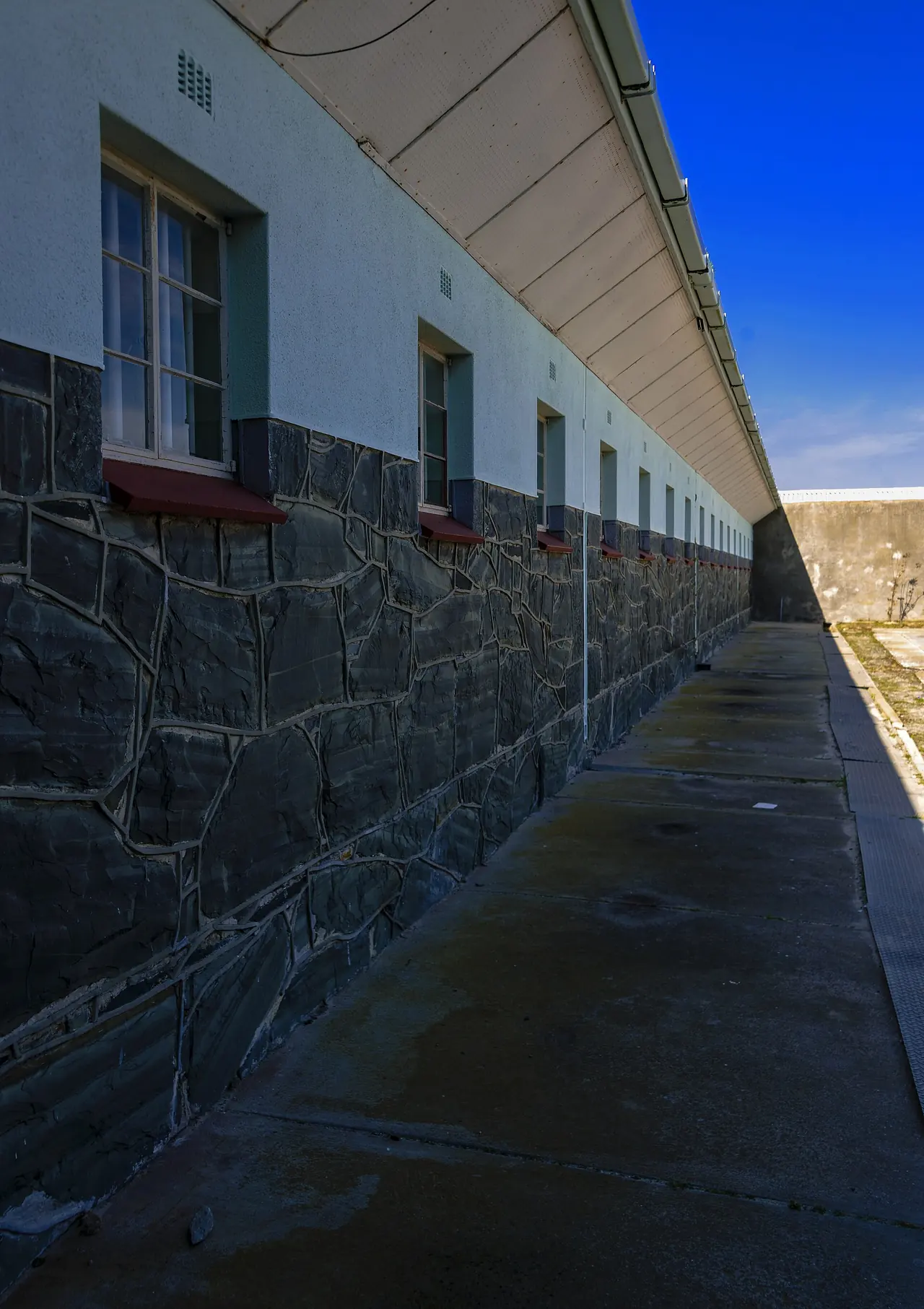 The barred windows of a cellblock along the prison wall
