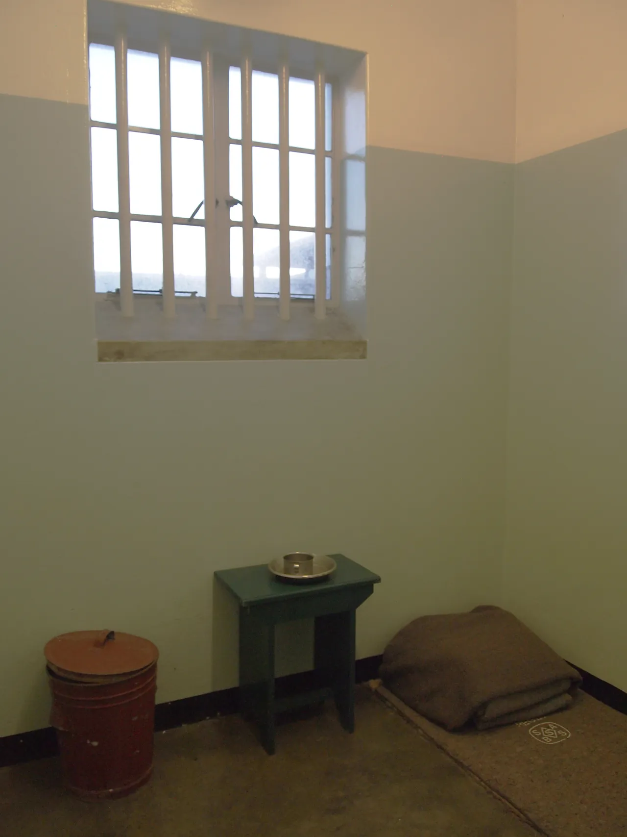 The barred window above the bedroll and table in Nelson Mandela's cell