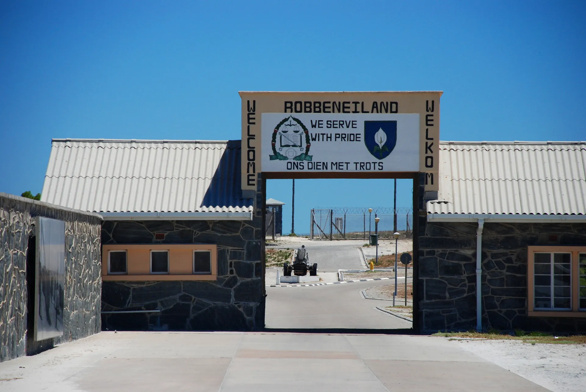 The prison entrance gate on Robben Island with its sign: We serve with pride