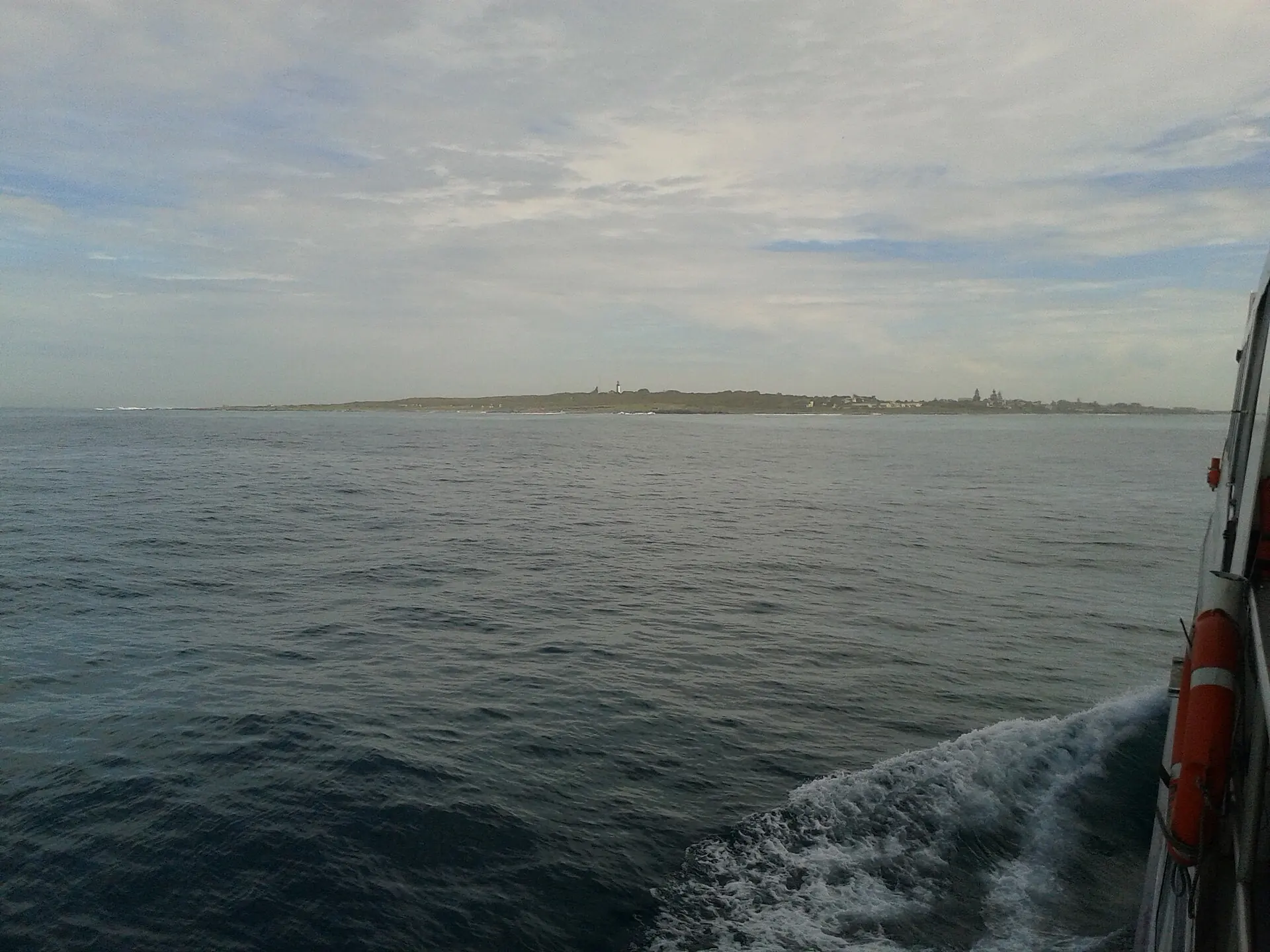 Robben Island seen low on the horizon from the deck of the ferry